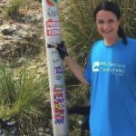 Person at signpost doing bike challenge, bike in background