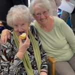 Members enjoying cake at Centre party